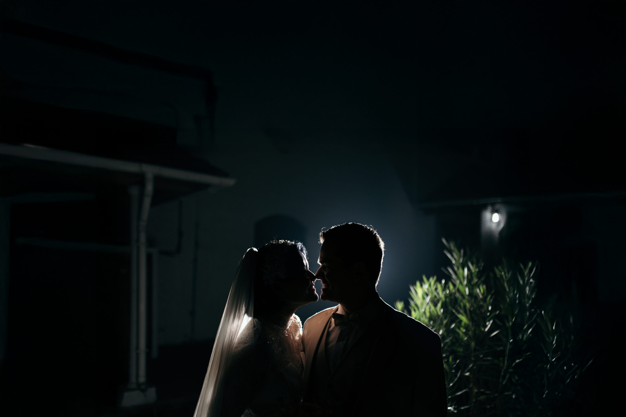 Pareja de novios celebrando con luces de fondo en su matrimonio, fotografía artística de boda" o "Novios en ambiente romántico con luces en su fiesta de matrimonio por Bodafilms